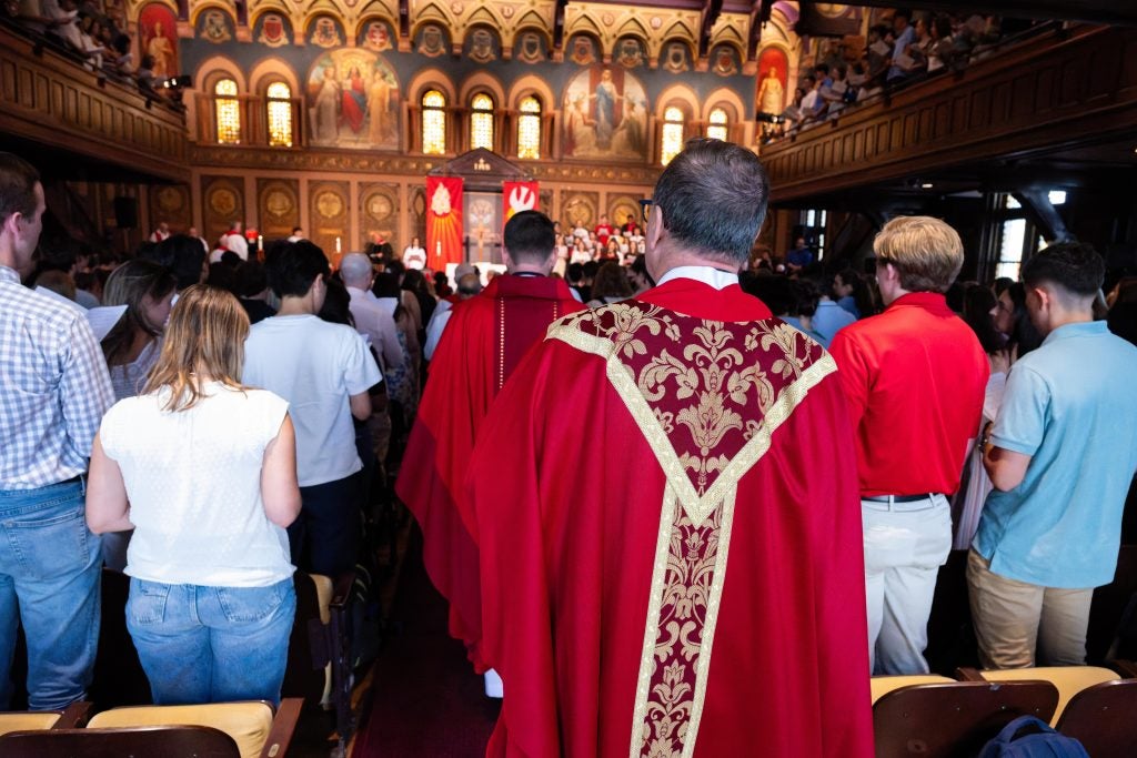 A priest walks into Gaston Hall to celebrate Mass