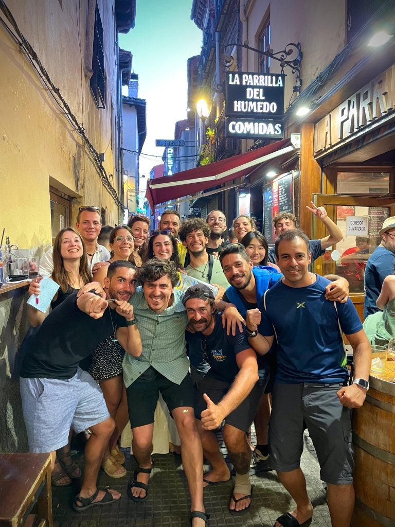 Group of people crowd together for a photo in a narrow street