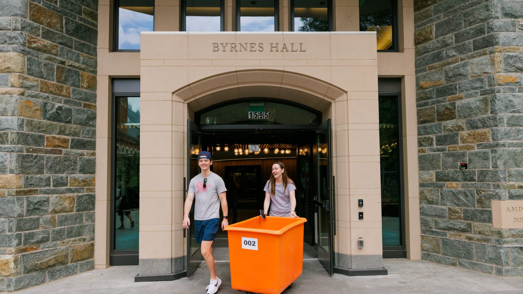 Students with a bin moving into dorm