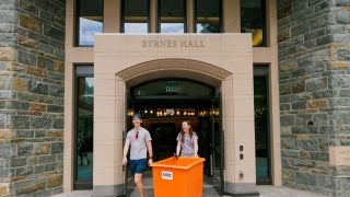 Students with a bin moving into dorm