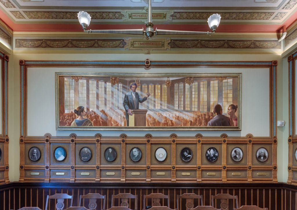 A painting of Frederick Douglass in a historic room
