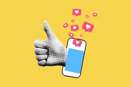 A yellow background with a hand signaling thumb-up next to a phone that&#039;s spurting &quot;like&quot; heart graphics out of it.