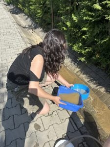 Young woman with a blue bucket with dirty water