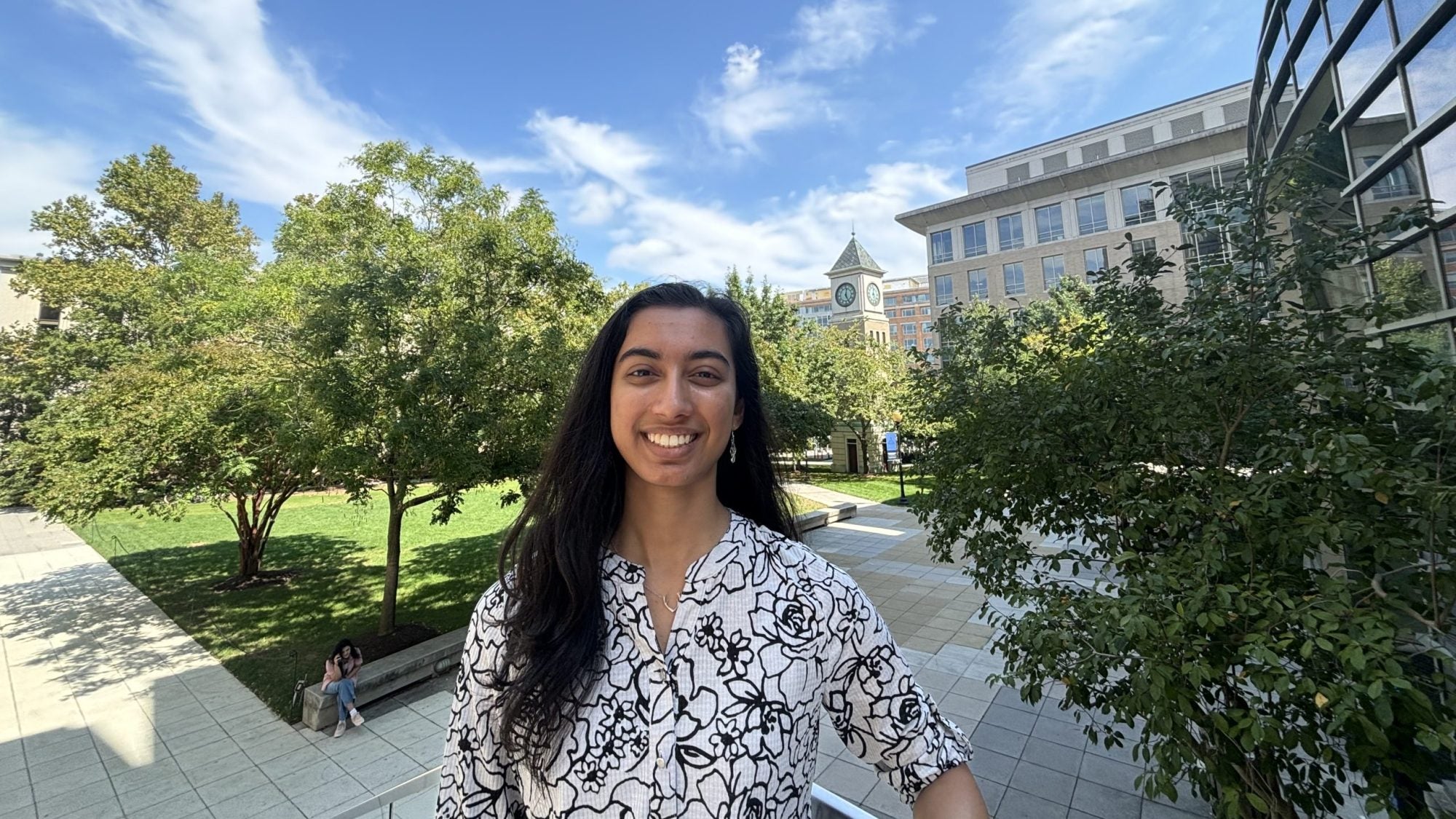 A female student smiles on a green campus