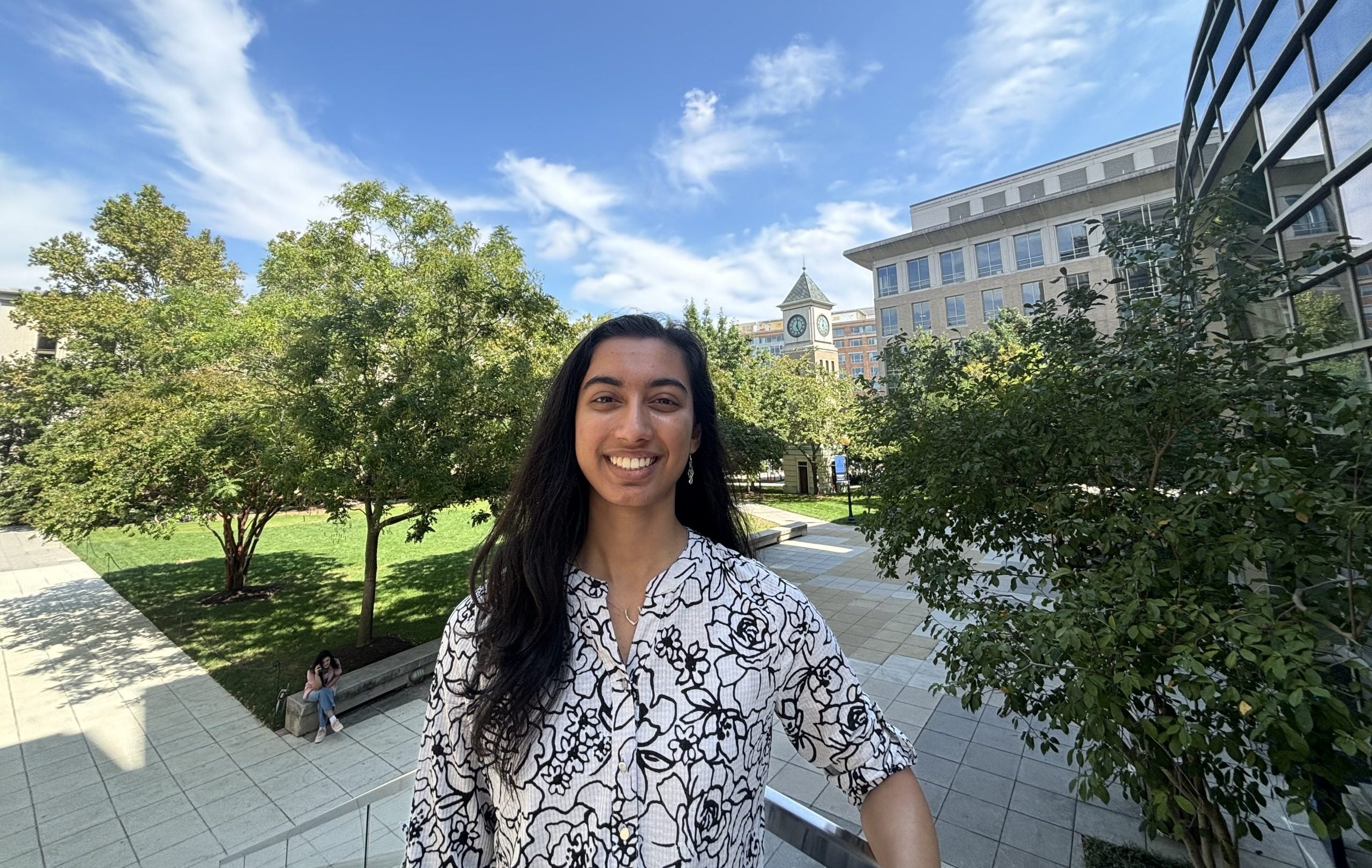A female student smiles on a green campus
