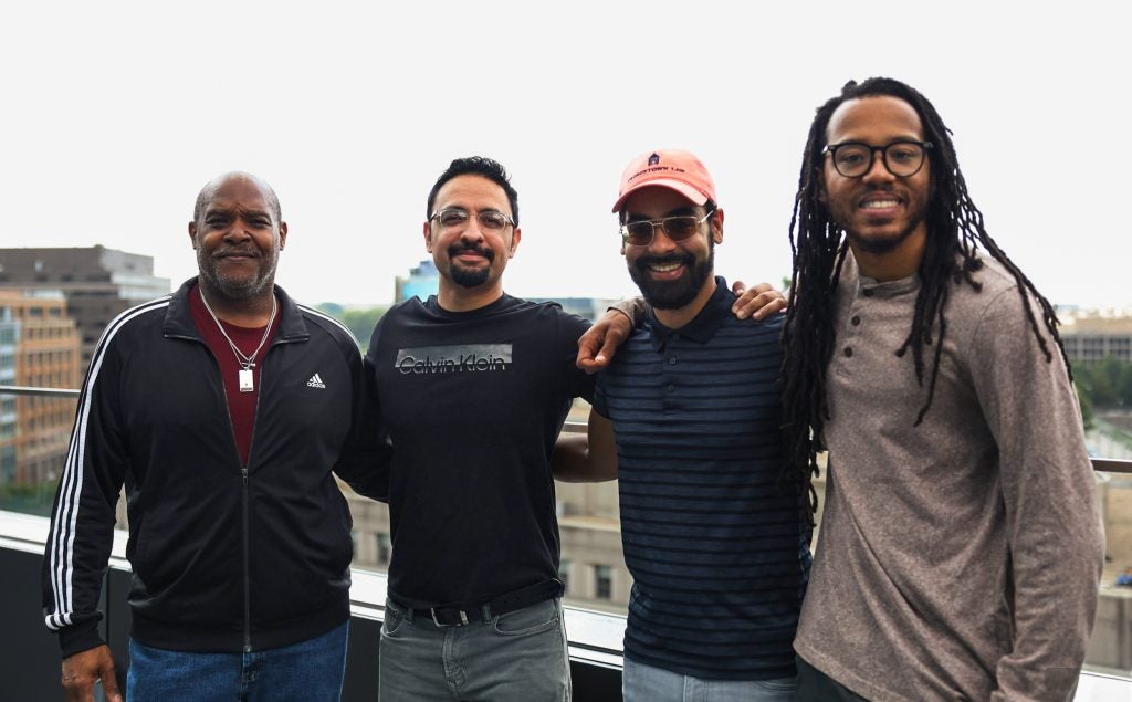 A group of men stand on a rooftop
