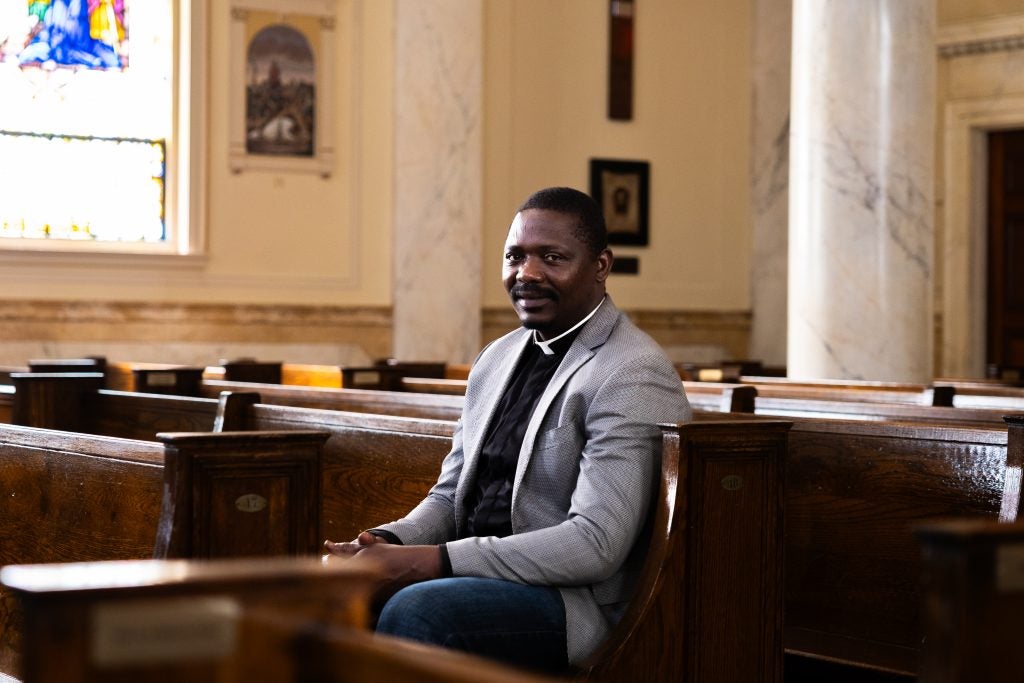 A man sits in a pew of a church