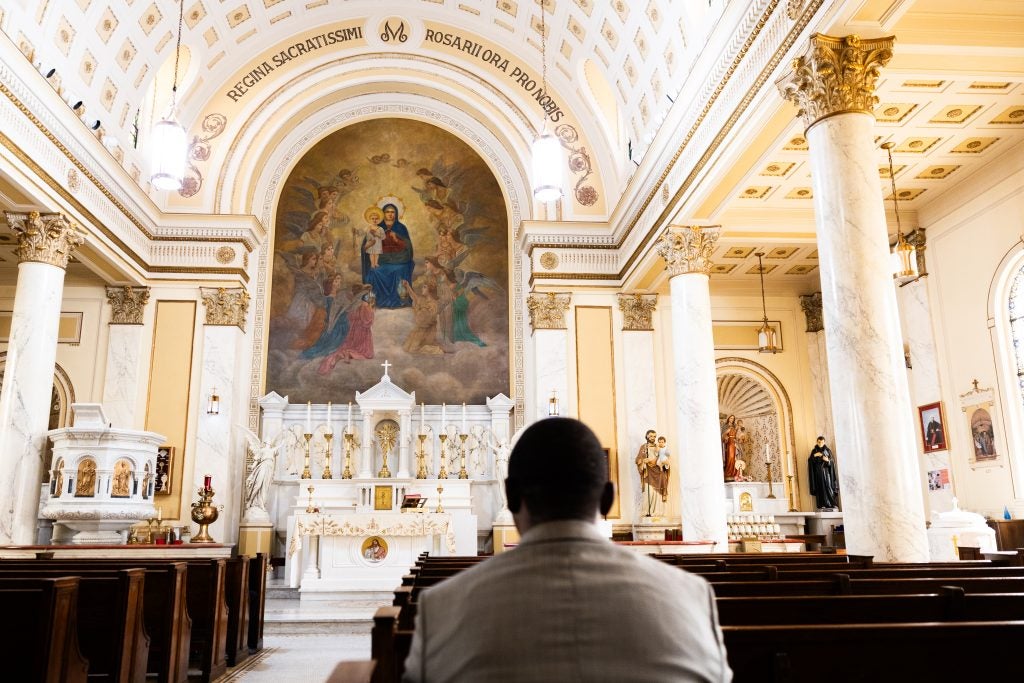 A man sits in church and prays
