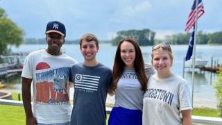 Three students with AP Journalist Meg Kinnard at a lake