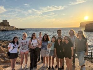 Students in the summer at a beach during sunset
