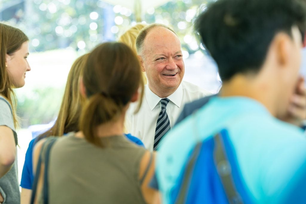 President Emeritus John DeGioia smiles amongst students
