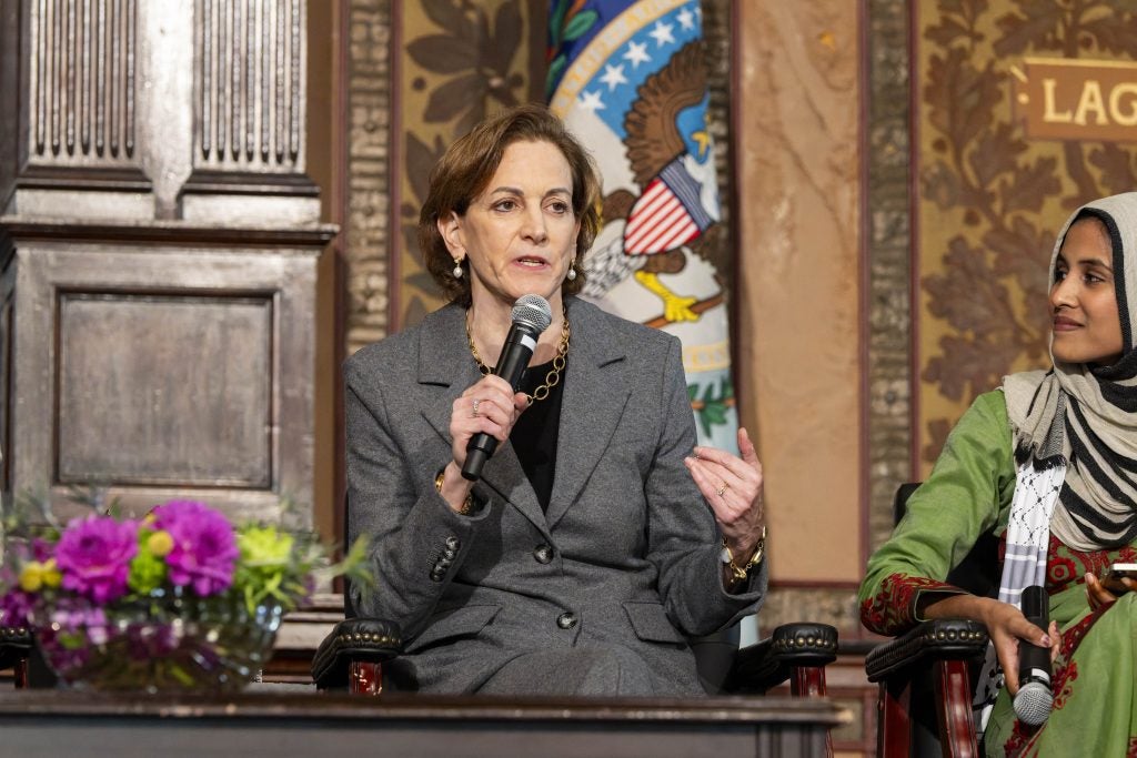 Anne Applebaum in a gray suit speaks on stage