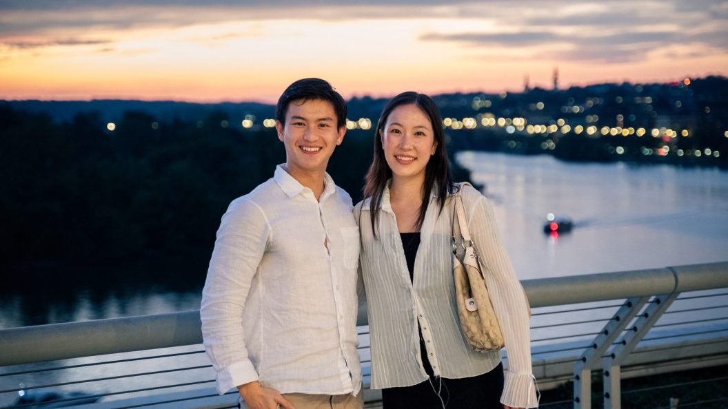Young Asian man and woman overlooking Potomac river at sunset