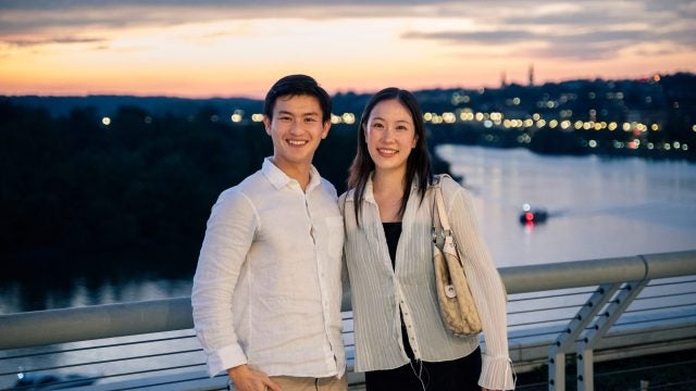 Young Asian man and woman overlooking Potomac river at sunset