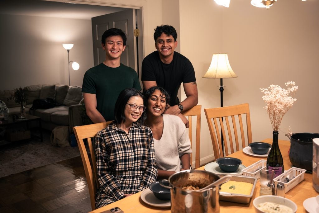Four young friends gathered for dinner at a table