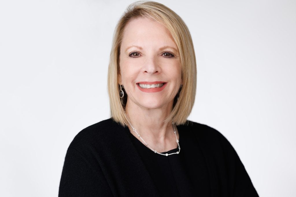 A woman with shoulder-length blonde hair smiles