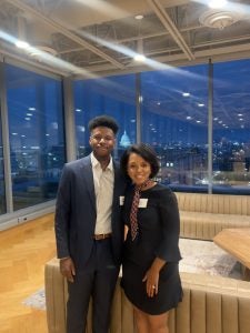 Justin Higgins next to a Black woman with the Capitol in the background at night at an event