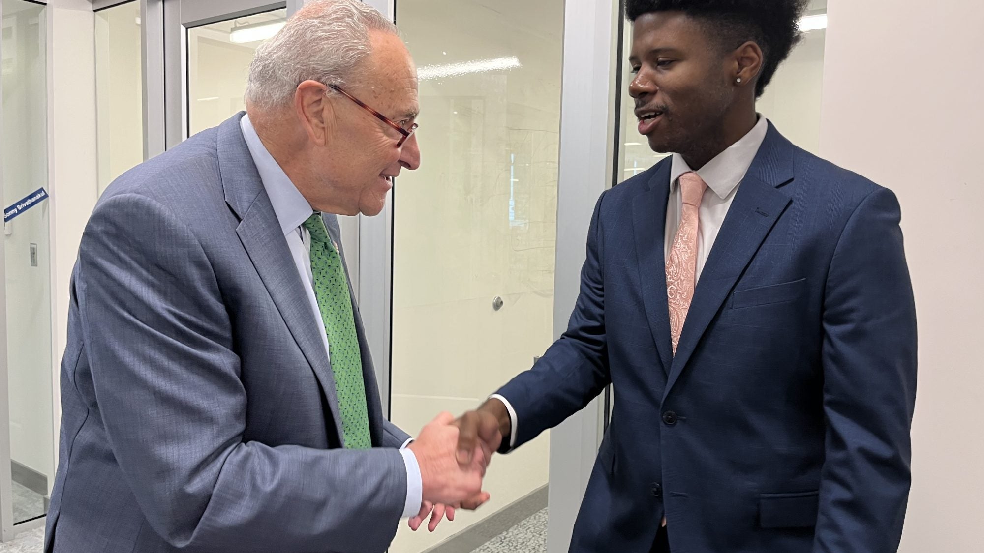 Justin Higgins shakes hands with Chuck Schumer