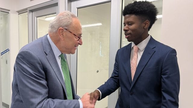 Justin Higgins shakes hands with Chuck Schumer