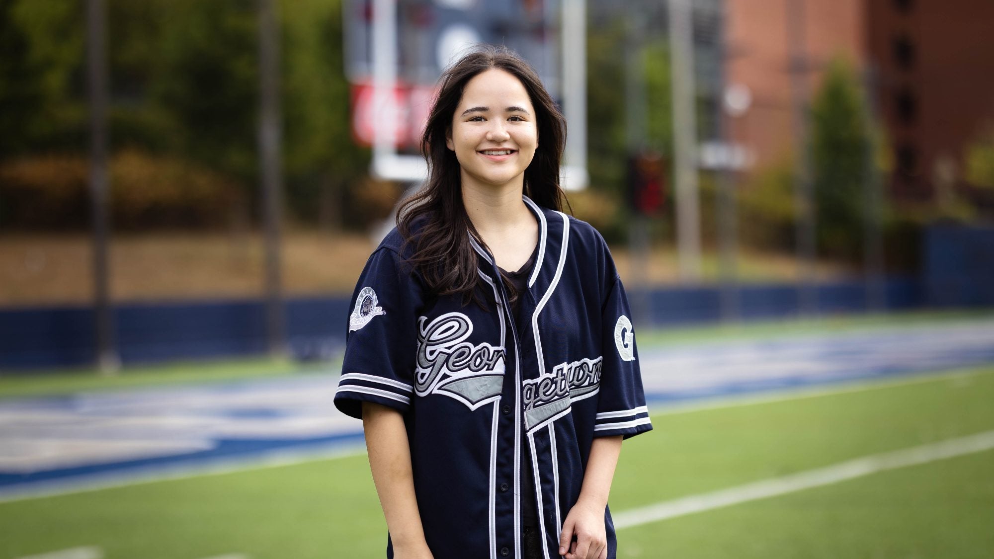 Juliette in a blue GU jersey on a football field