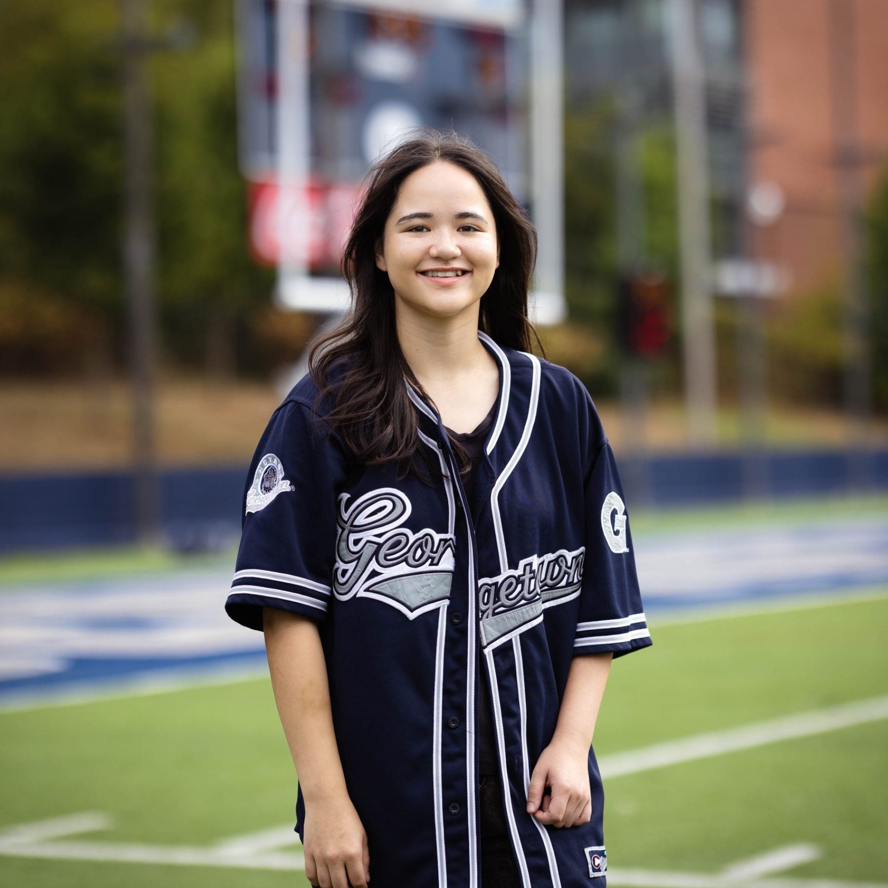 Juliette in a blue GU jersey on a football field