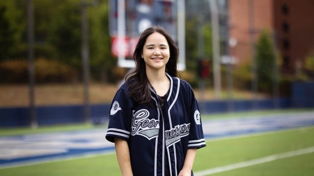 Juliette in a blue GU jersey on a football field