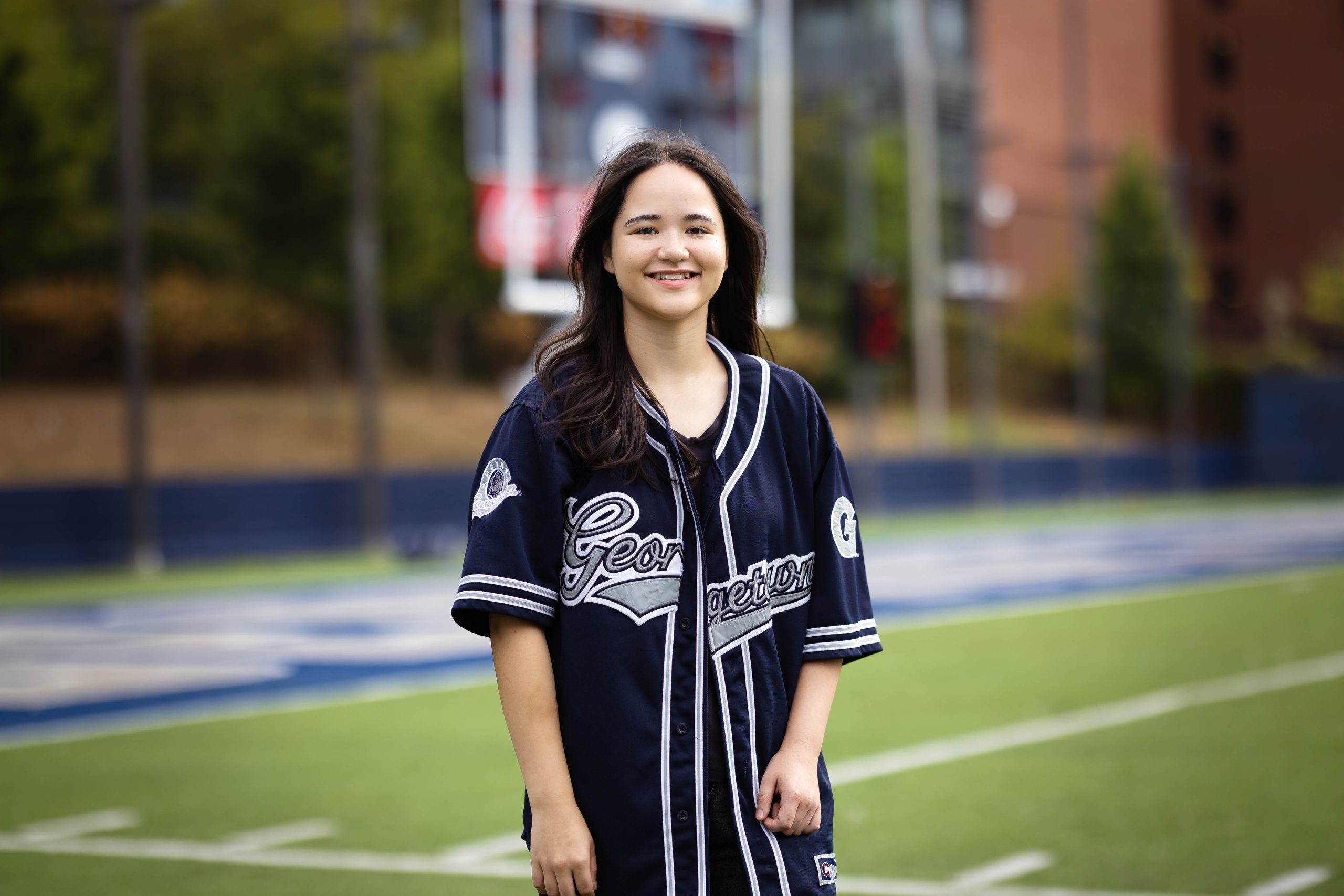 Juliette in a blue GU jersey on a football field