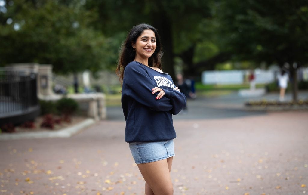 Harnoor in a blue GU sweatshirt on a fall day