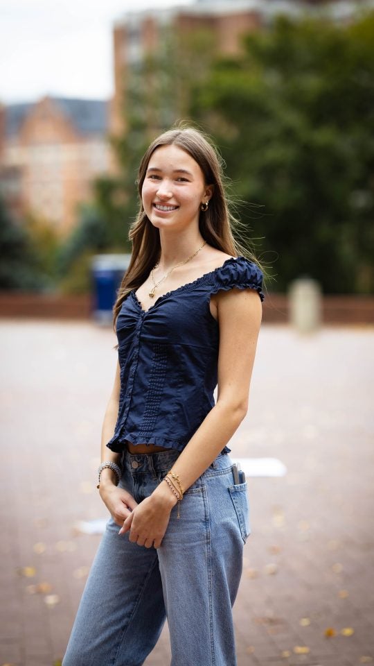 Zoe in a blue blouse on the GU campus on a cloudy day