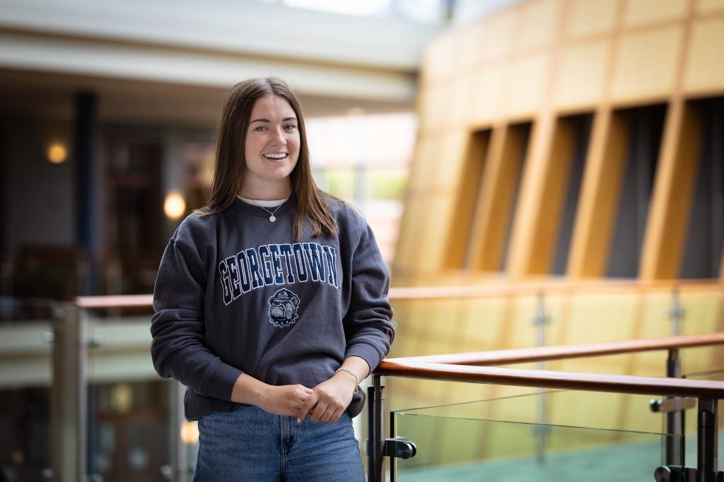 Sarah in gray GU sweatshirt in the Hariri building