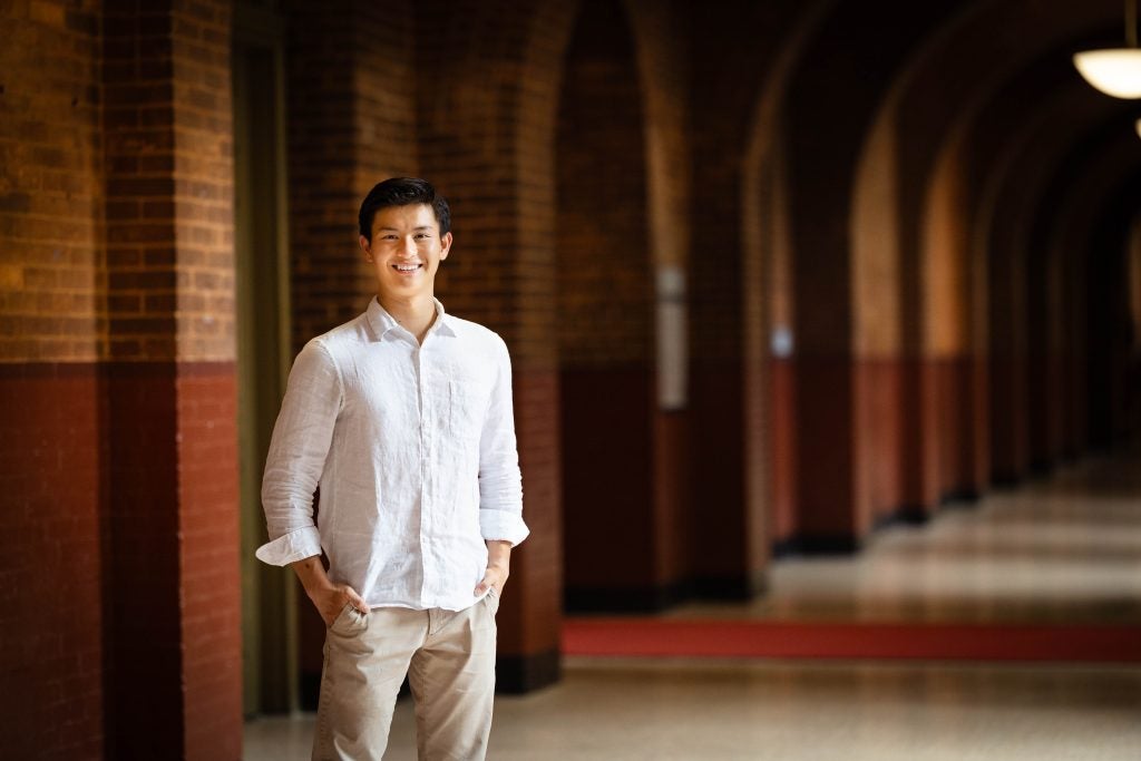 Bennie in a white shirt in a dark hallway