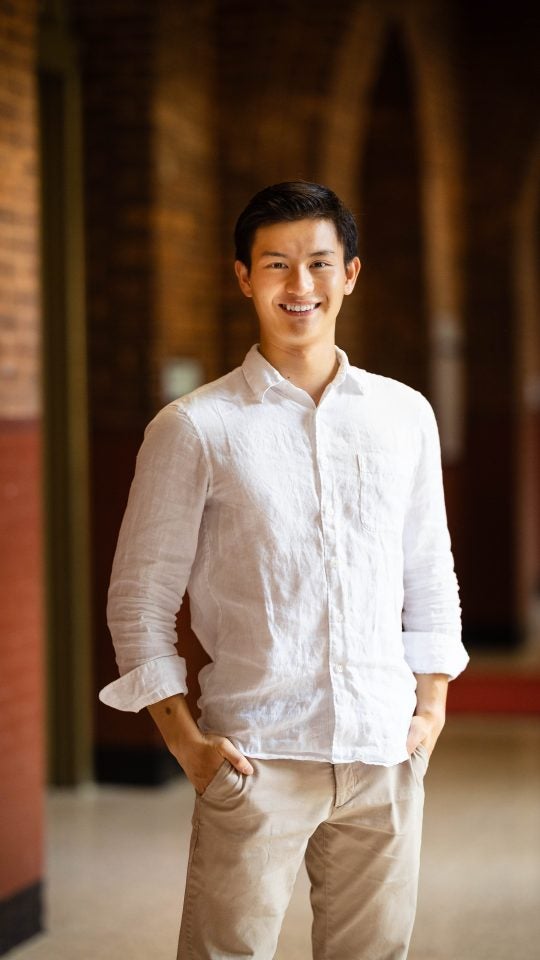 Bennie in a white shirt in a dark hallway