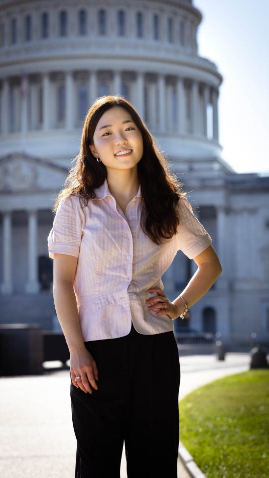 Ashley in a pink blouse in front of the US Capitol