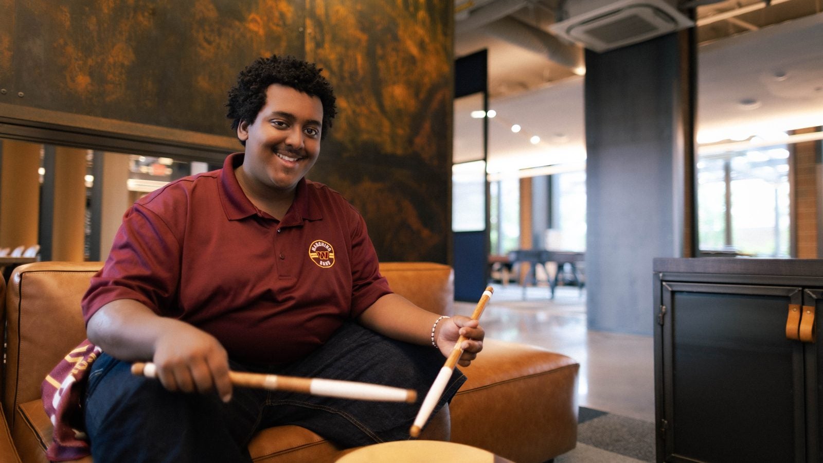 Young Black man smiling with a drum set