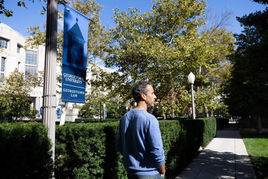A man walks through Georgetown Law's campus on a sunny day