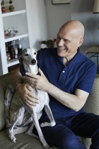 Tom Sietsema poses with his dog in his home.