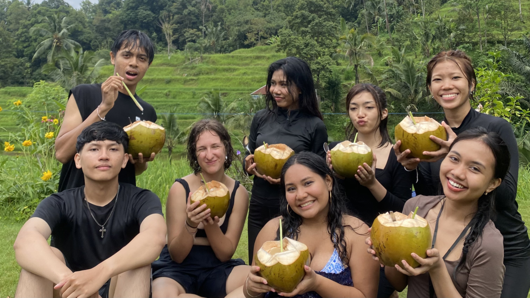A group of students holding coconuts and in black clothing