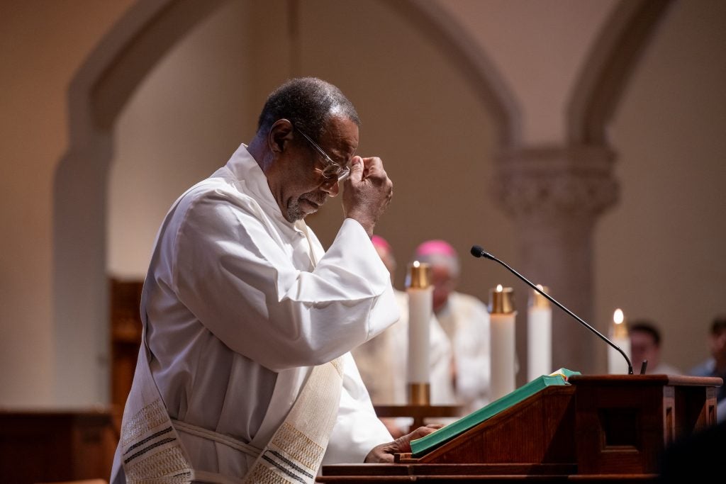 A Black Catholic priest at the podium in Dahlgren Chapel