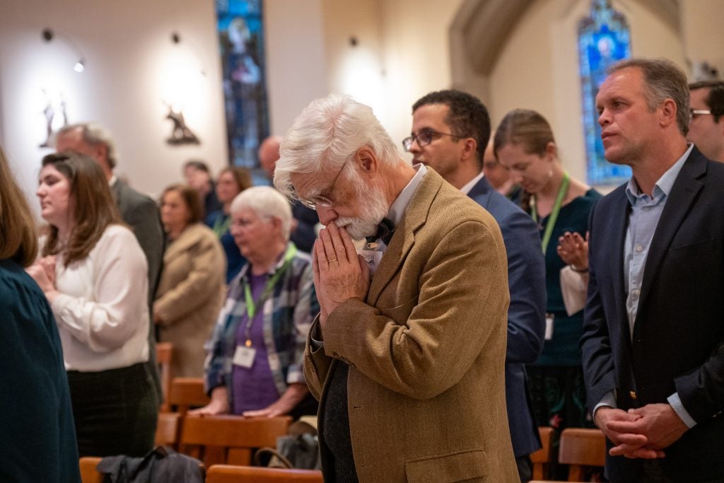 An older Caucasian man in prayer while in Dahlgren Chapel