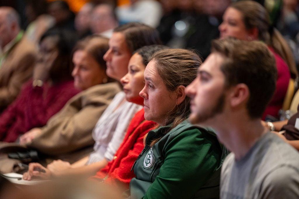 A group of people listen to a speaker
