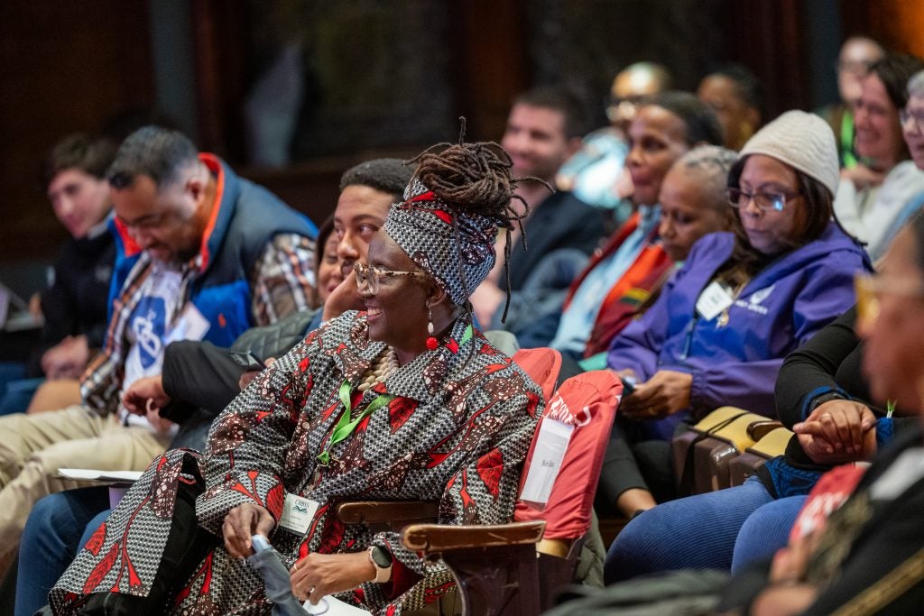A group of Black people listen to a presentation