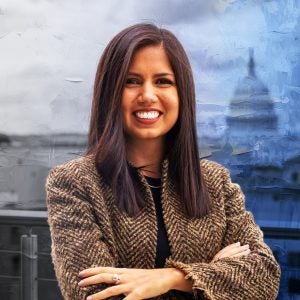 Hispanic woman in a coat with her arms crossed