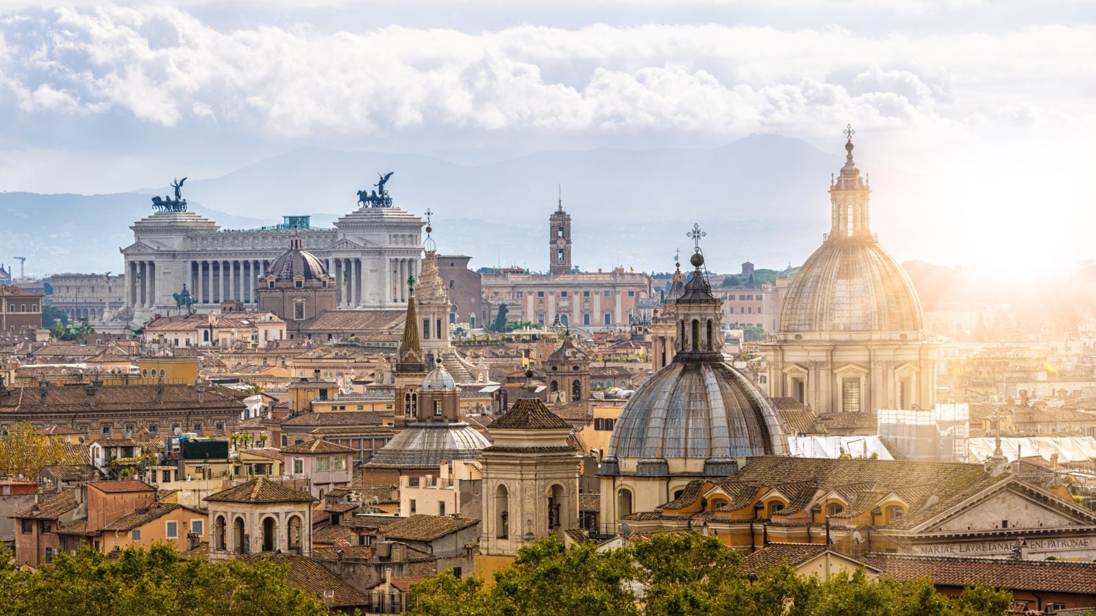 The skyline of the Vatican in Rome with sunlight streaming onto a building