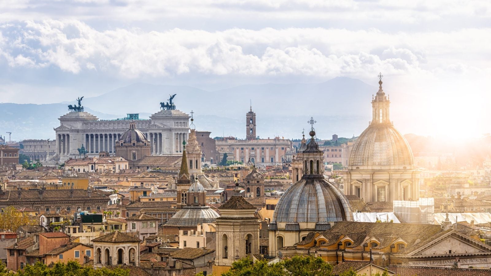 The skyline of the Vatican in Rome with sunlight streaming onto a building