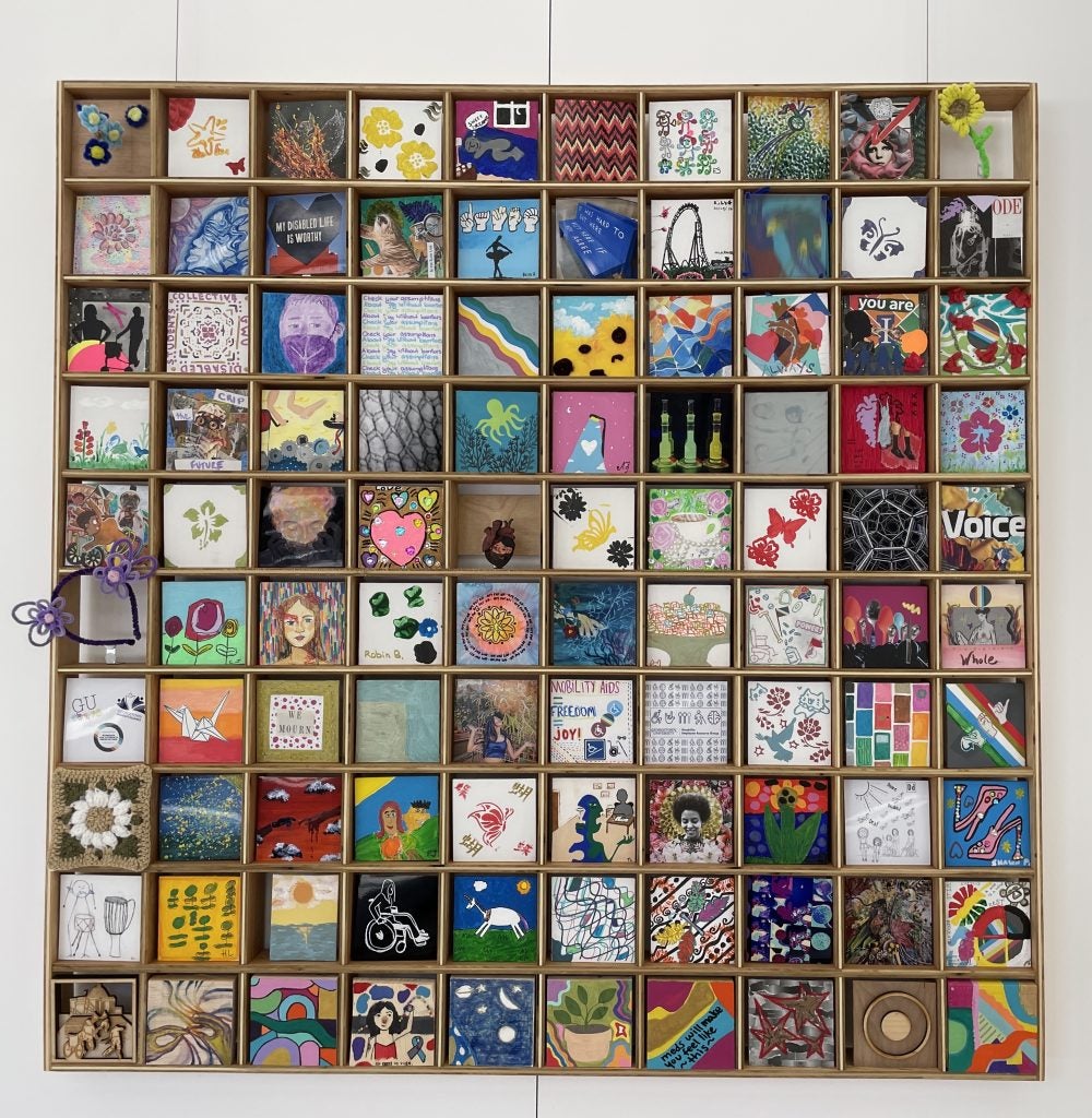 100 multi-colored squares are displayed in an exhibit