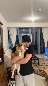 Kiumars holding his dog indoors