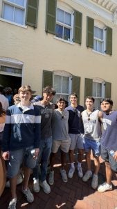 A group of young men in Georgetown gear in front of a row house