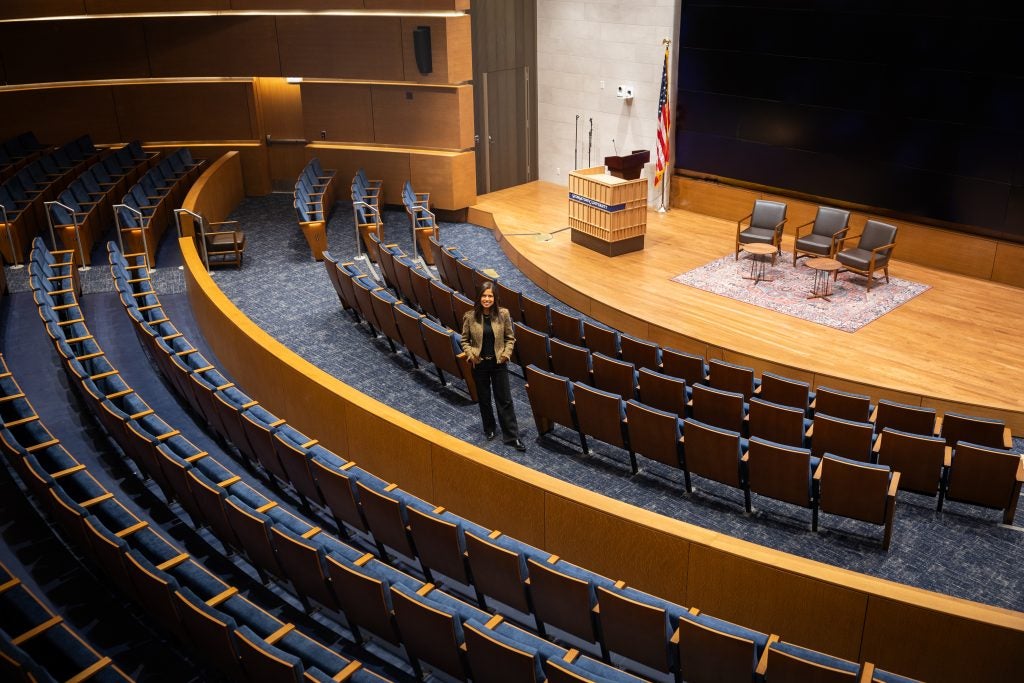 Hispanic woman standing in an empty auditorium