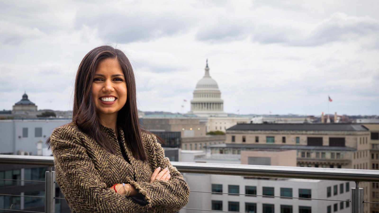 Hispanic woman on a balcony overlooking the US Capitol