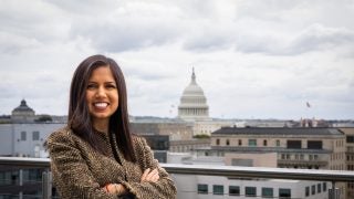 Hispanic woman on a balcony overlooking the US Capitol
